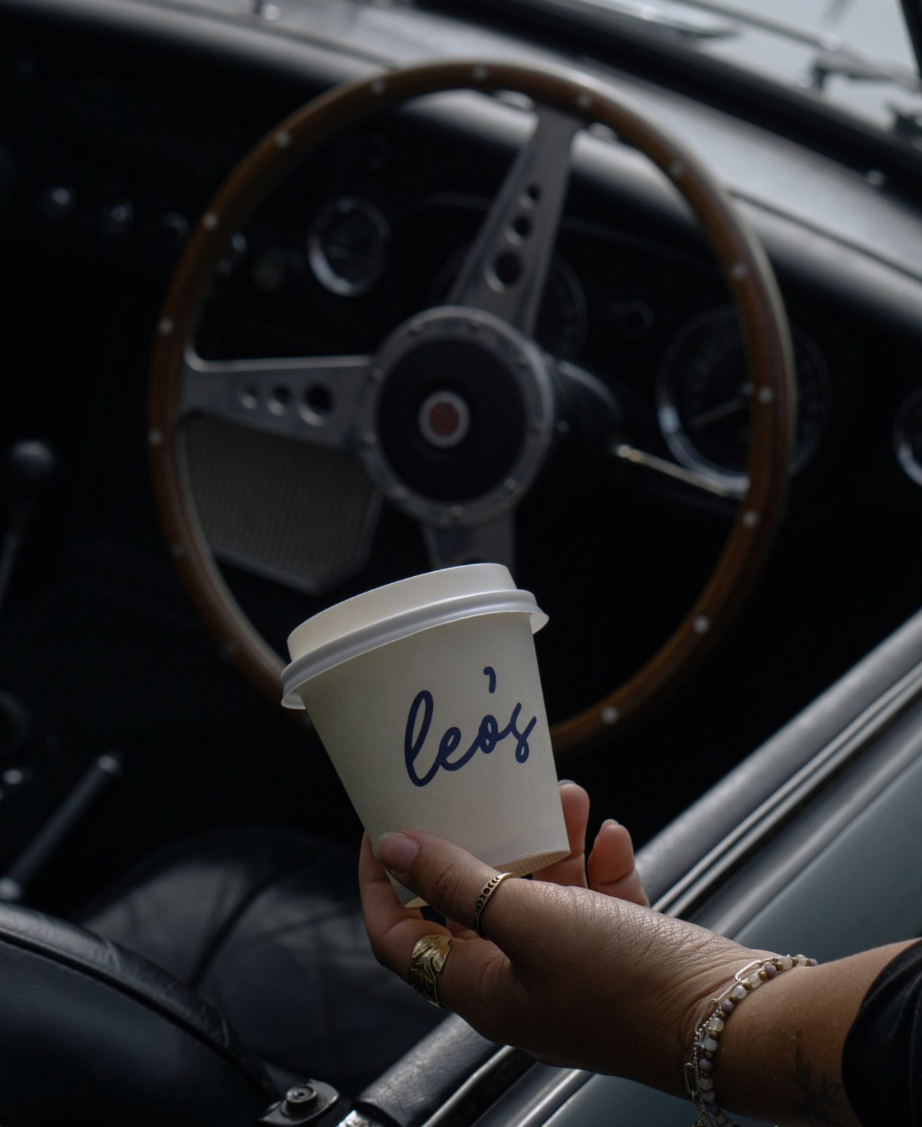 A Leo's cup held inside a classic car